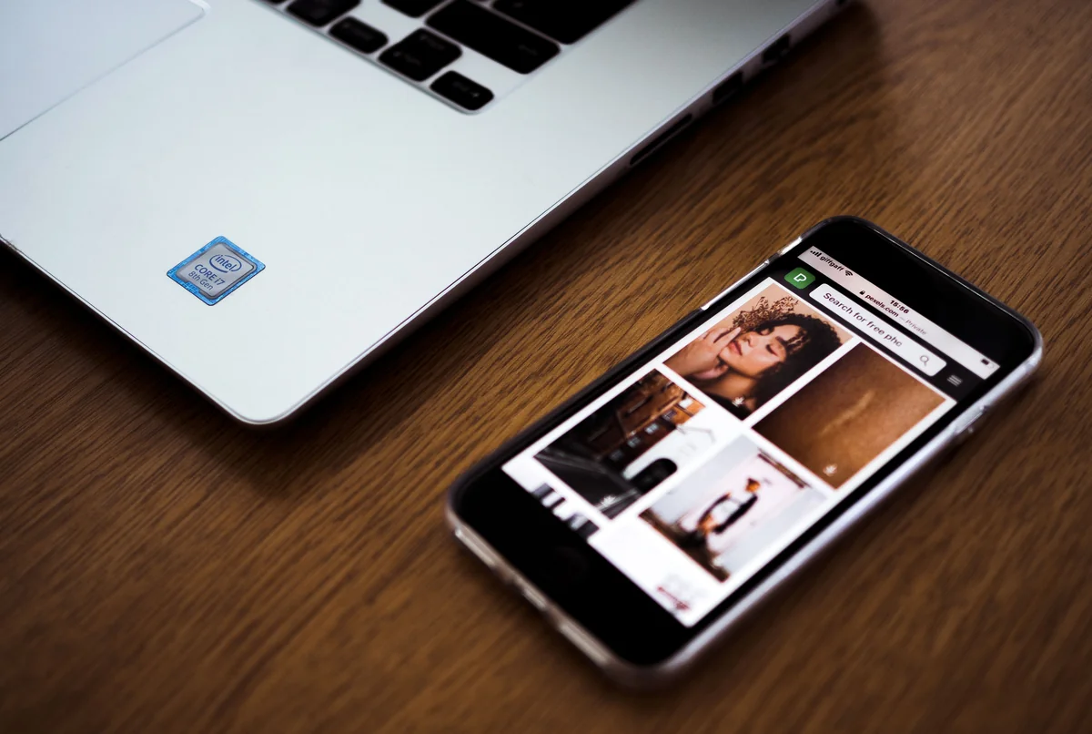 Smartphone und Laptop liegen nebeneinander bei der Recherche zu einer App