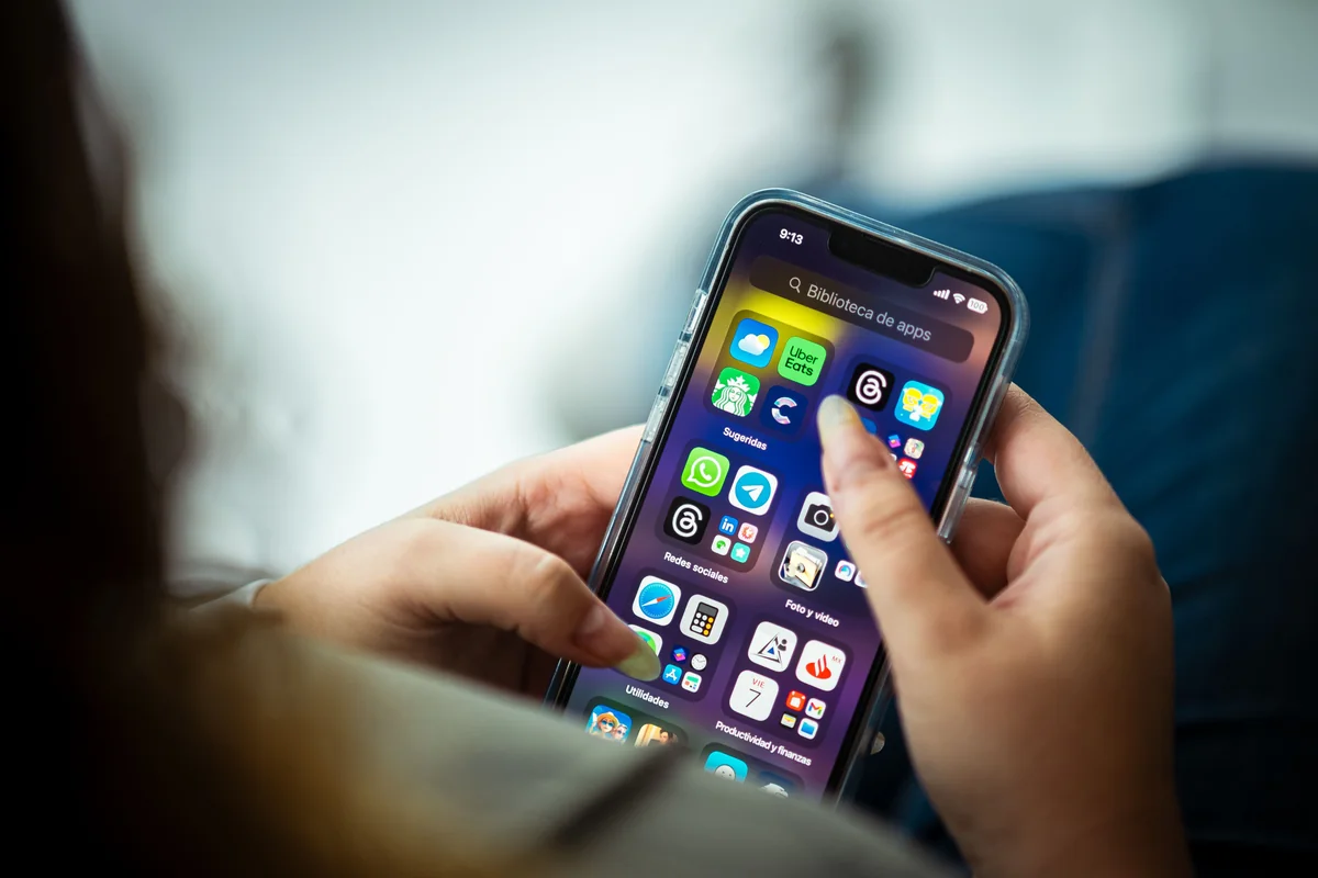 Hand scrollt auf einem Smartphone durch App-Icons bei der Appsuche