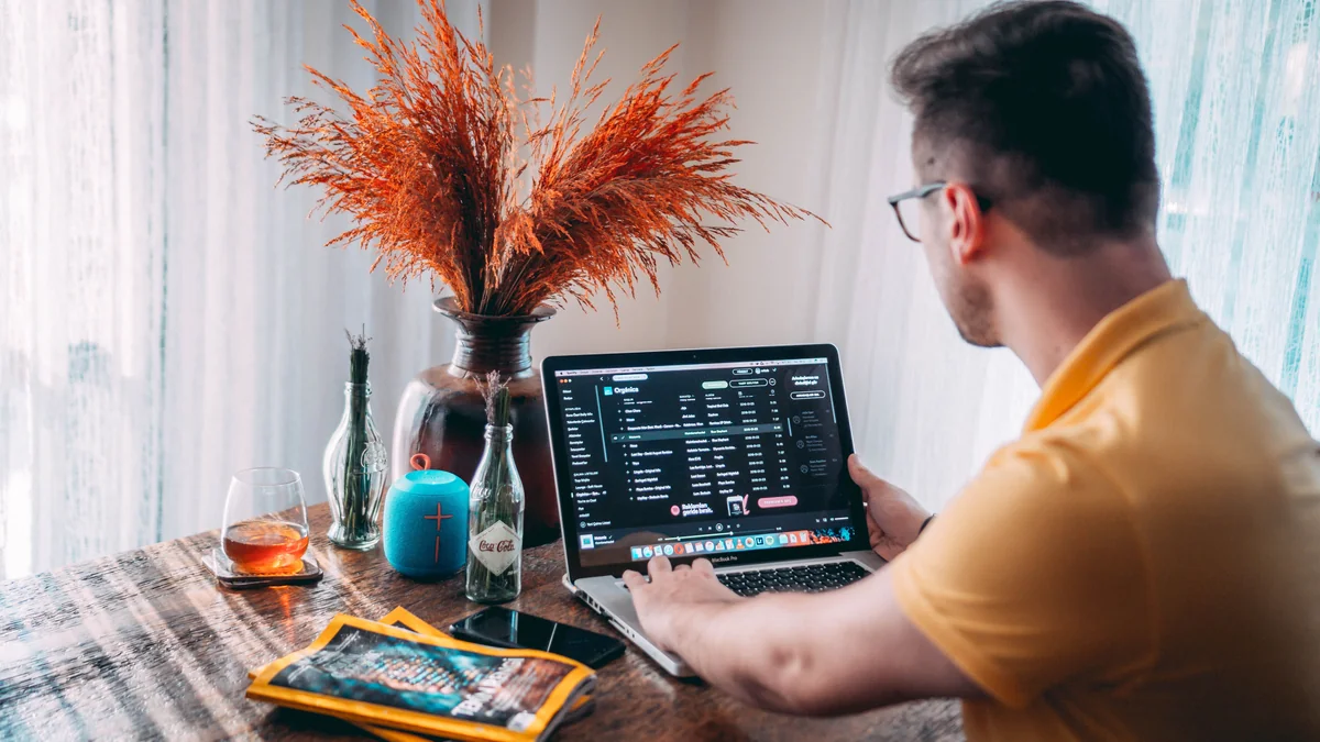 Person streamt eine Video-App auf einem MacBook im Wohnzimmer