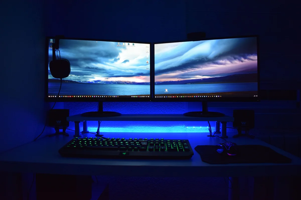 Windows-Desktop-Computer-Setup mit zwei Monitoren und beleuchteter Tastatur