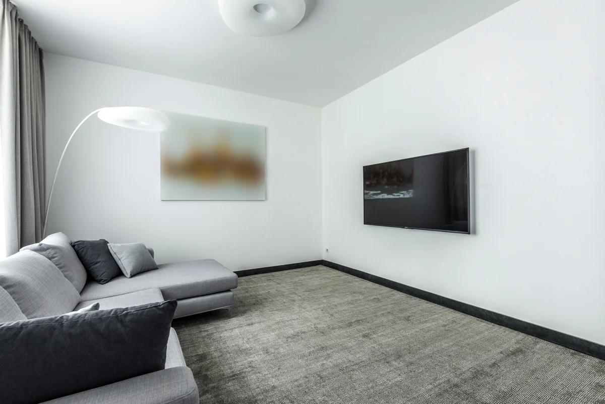 Flachbild-Fernseher an einer Wohnzimmerwand über einer Couch montiert