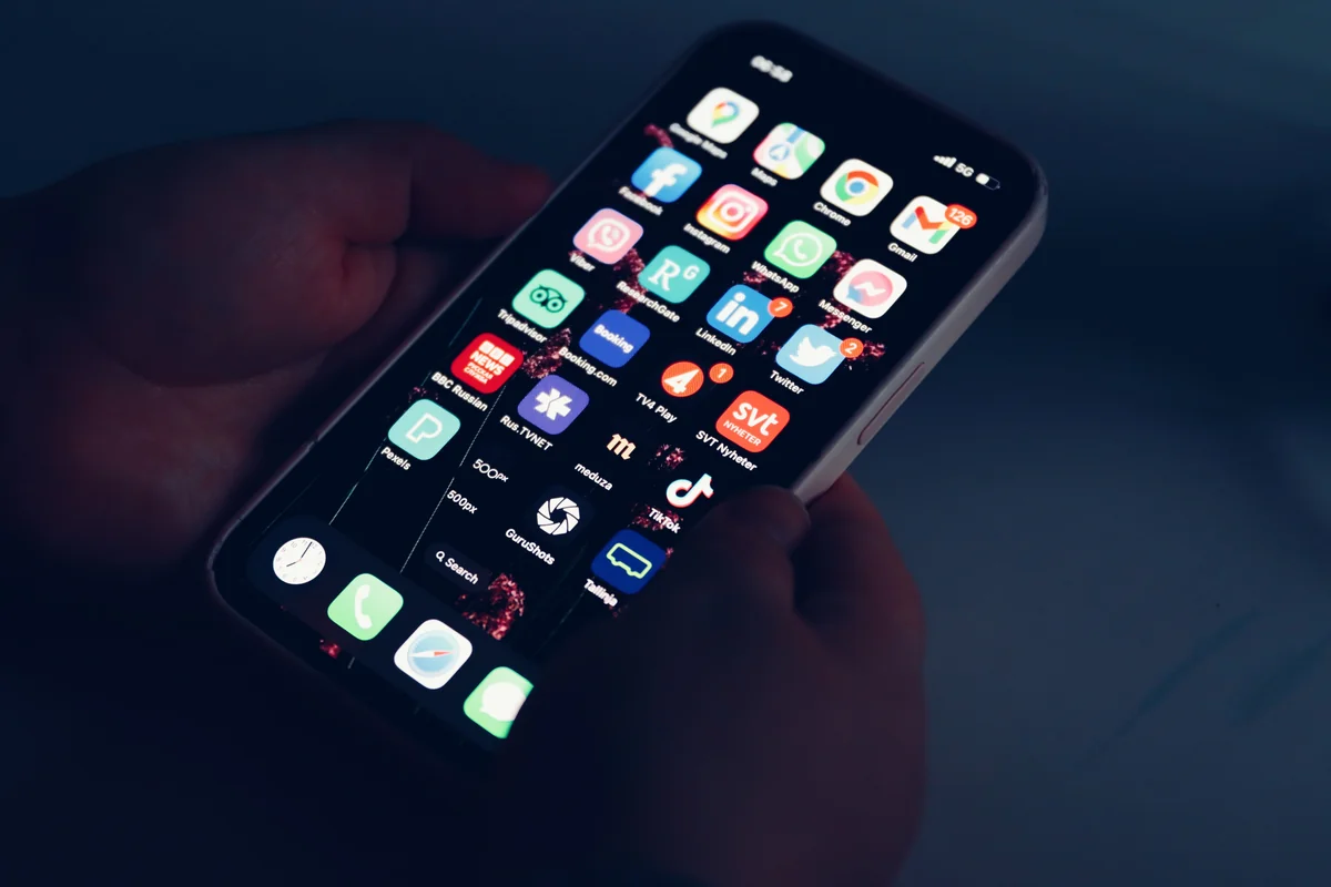 Hand met een iPhone tijdens het bladeren door apps voordat er een wordt geïnstalleerd vanuit de App Store