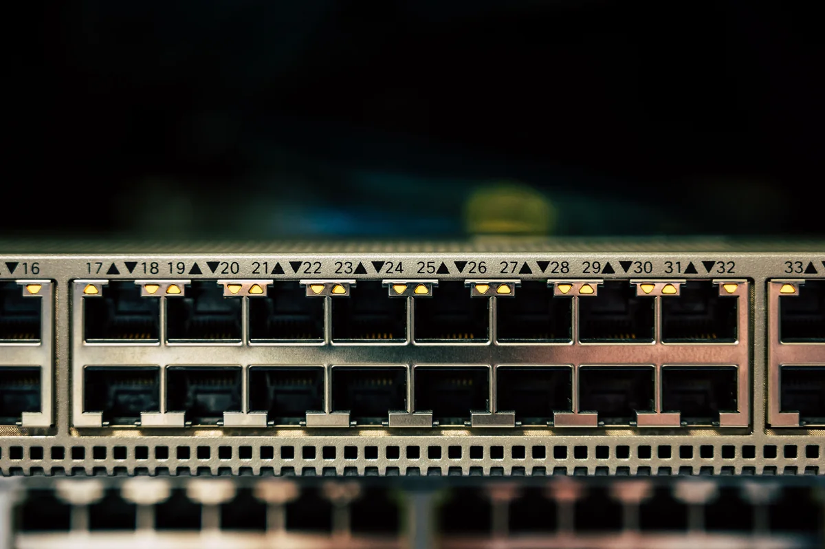 Primer plano de los puertos de un switch de red, que representa la conexión por cable detrás de un streaming 4K estable