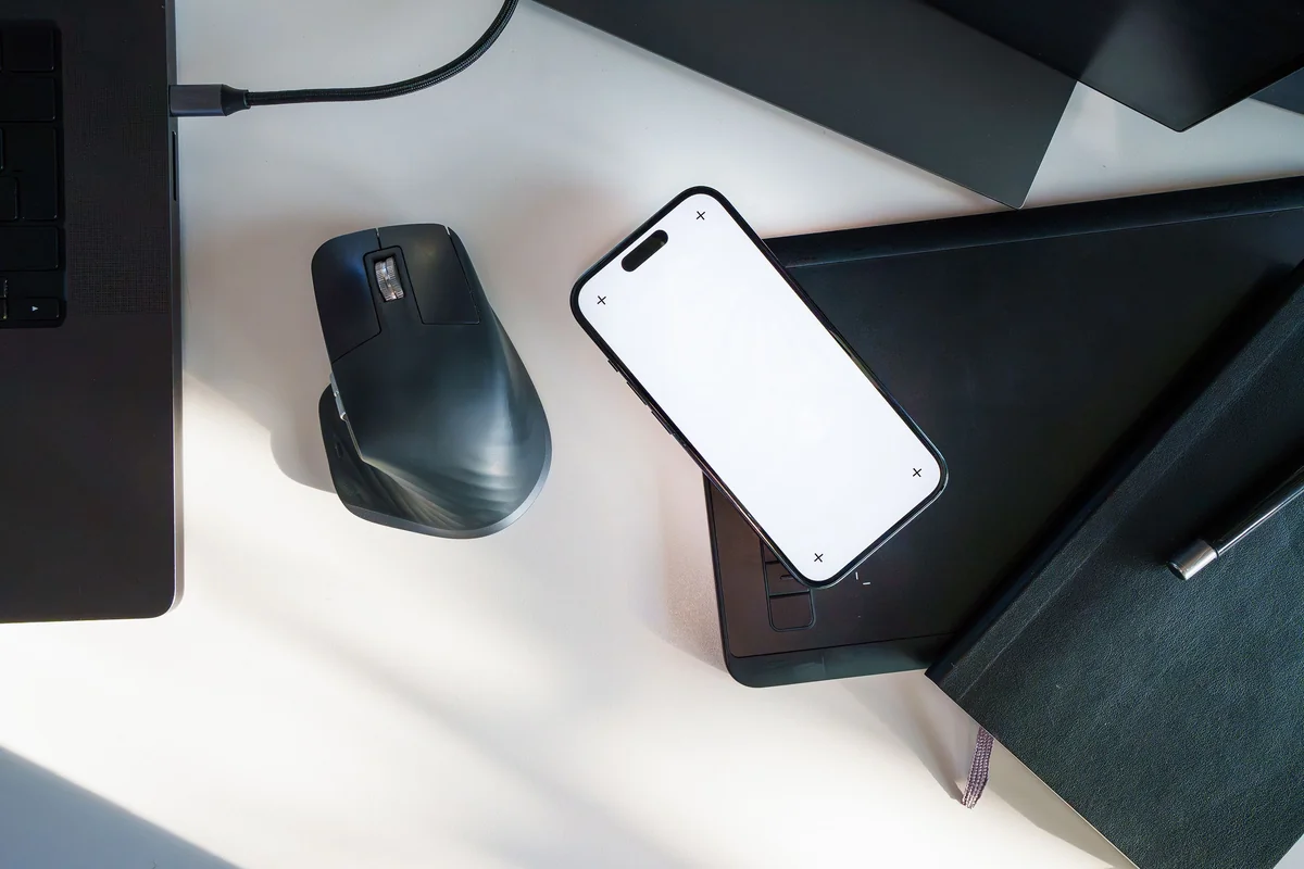 Smartphone, Tablet und Laptop nebeneinander auf einem Schreibtisch für einen geräteübergreifenden Vergleich