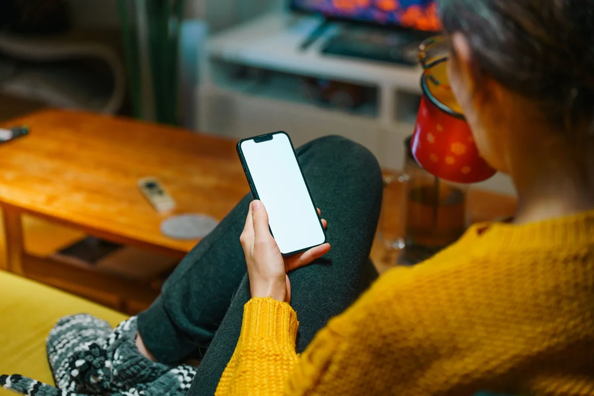 Ekrany telefonu i telewizora lustrzanie odtwarzane razem podczas przesyłania wideo w salonie