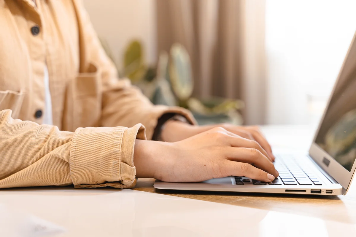 Persona escribiendo datos de acceso en un portátil sobre un escritorio