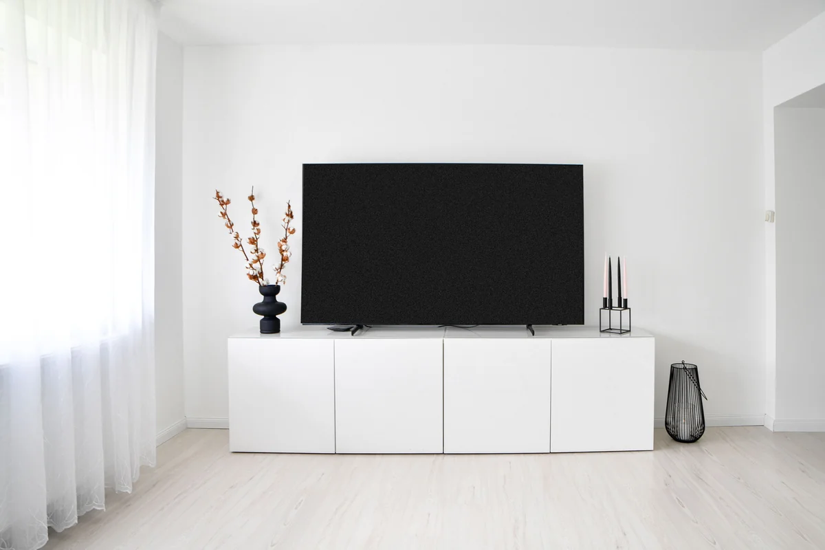 Televisor grande de pantalla plana en un salón luminoso y minimalista
